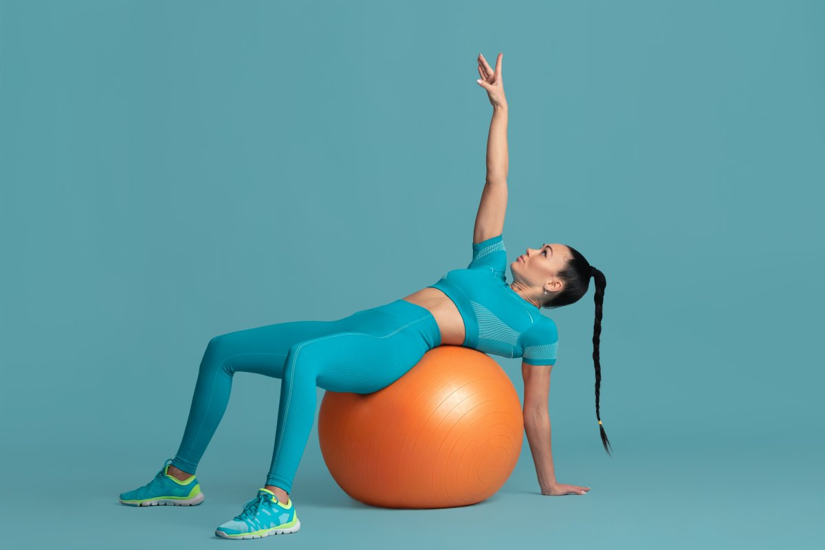 Gymnastický míč lze využívat jako náhradu lavičky při cvičení
